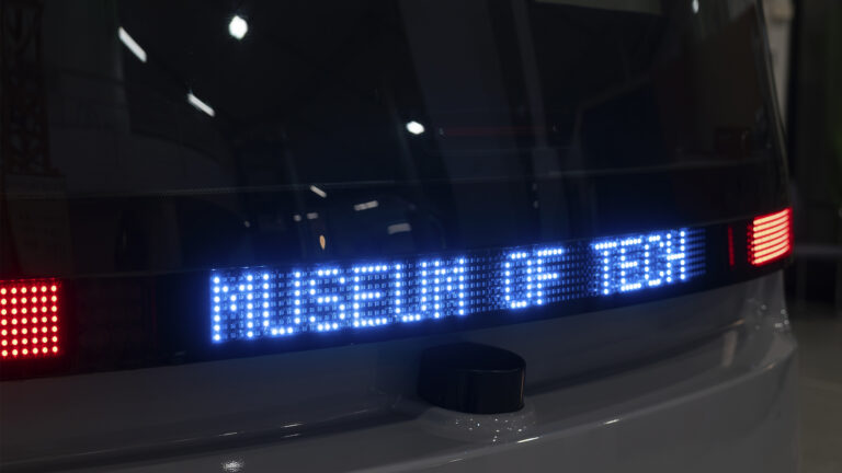 Self driving bus at the Museum of Technology with the next stop marked as Museum of Tech